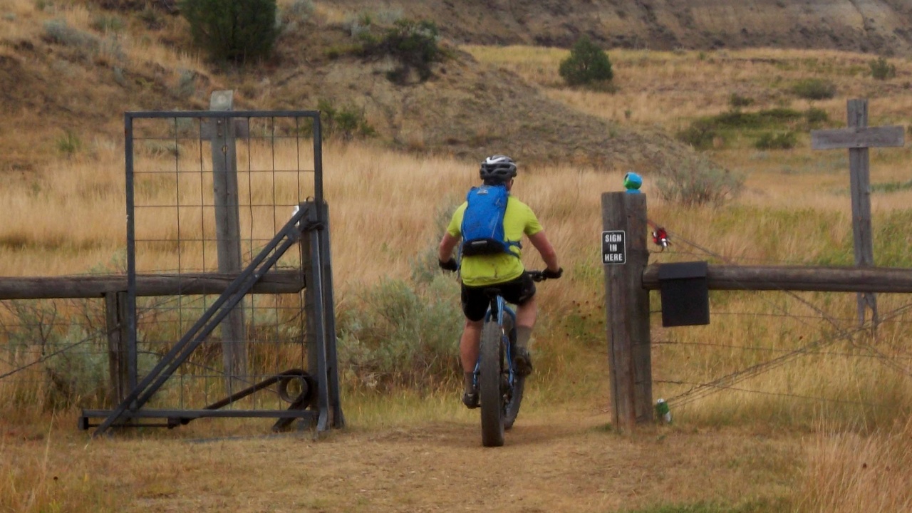 Cyclists on the Maah Daah Hey Trail passing badlands and prairie