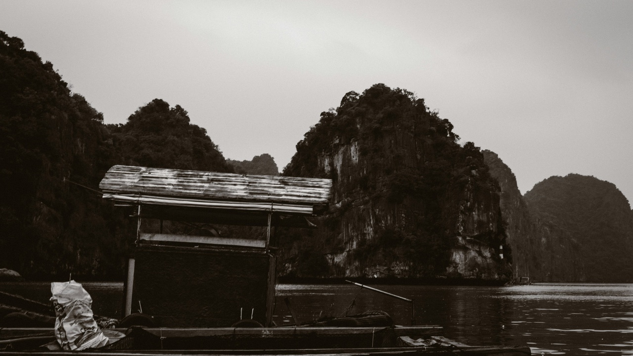 Boat cruising among limestone karsts at Halong Bay.