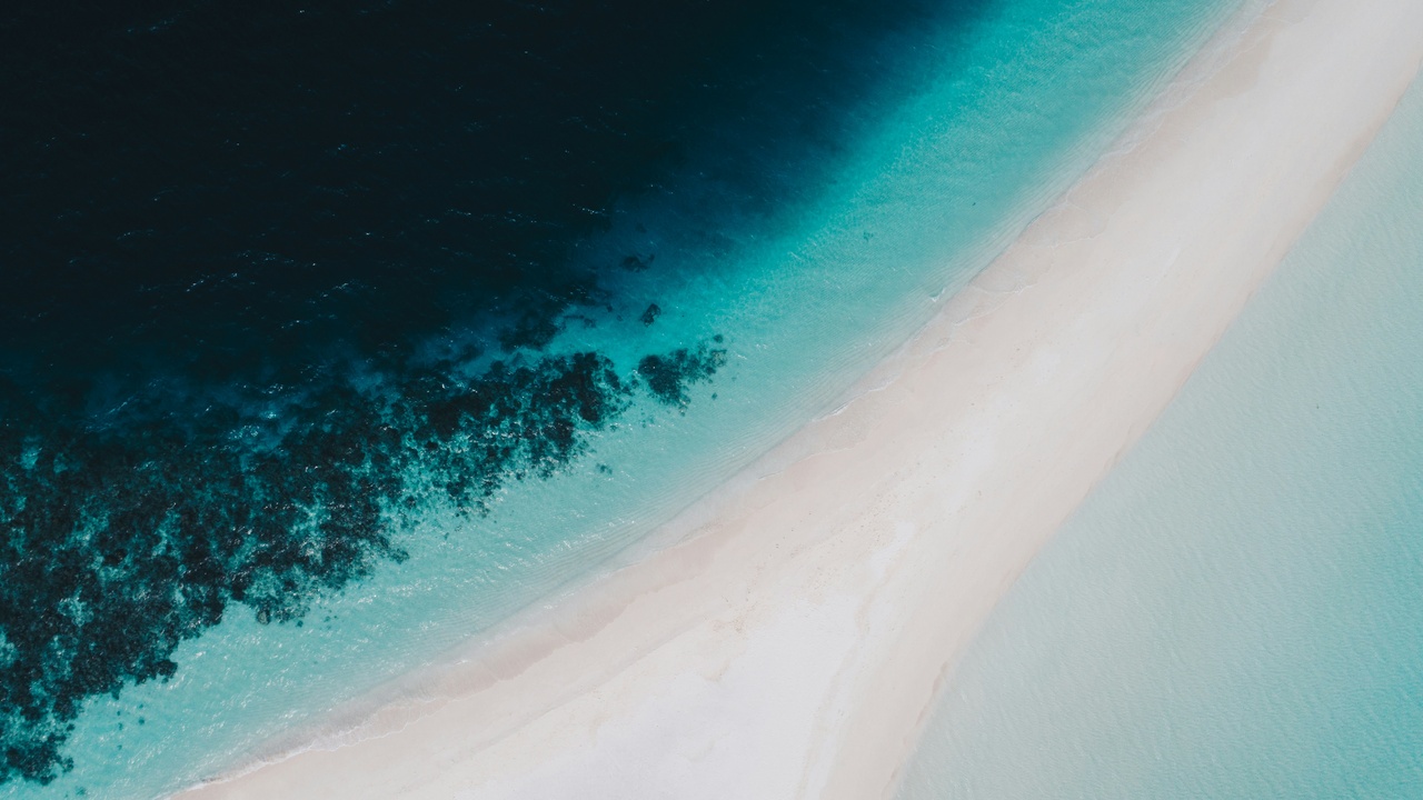 Clear turquoise lagoon with kayakers and a coral reef in the Marshall Islands