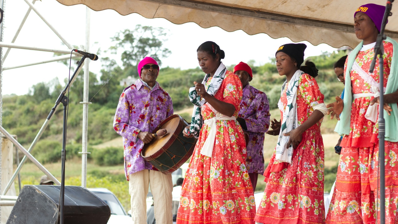 Malagasy family gathered near a traditional house during a village ceremony