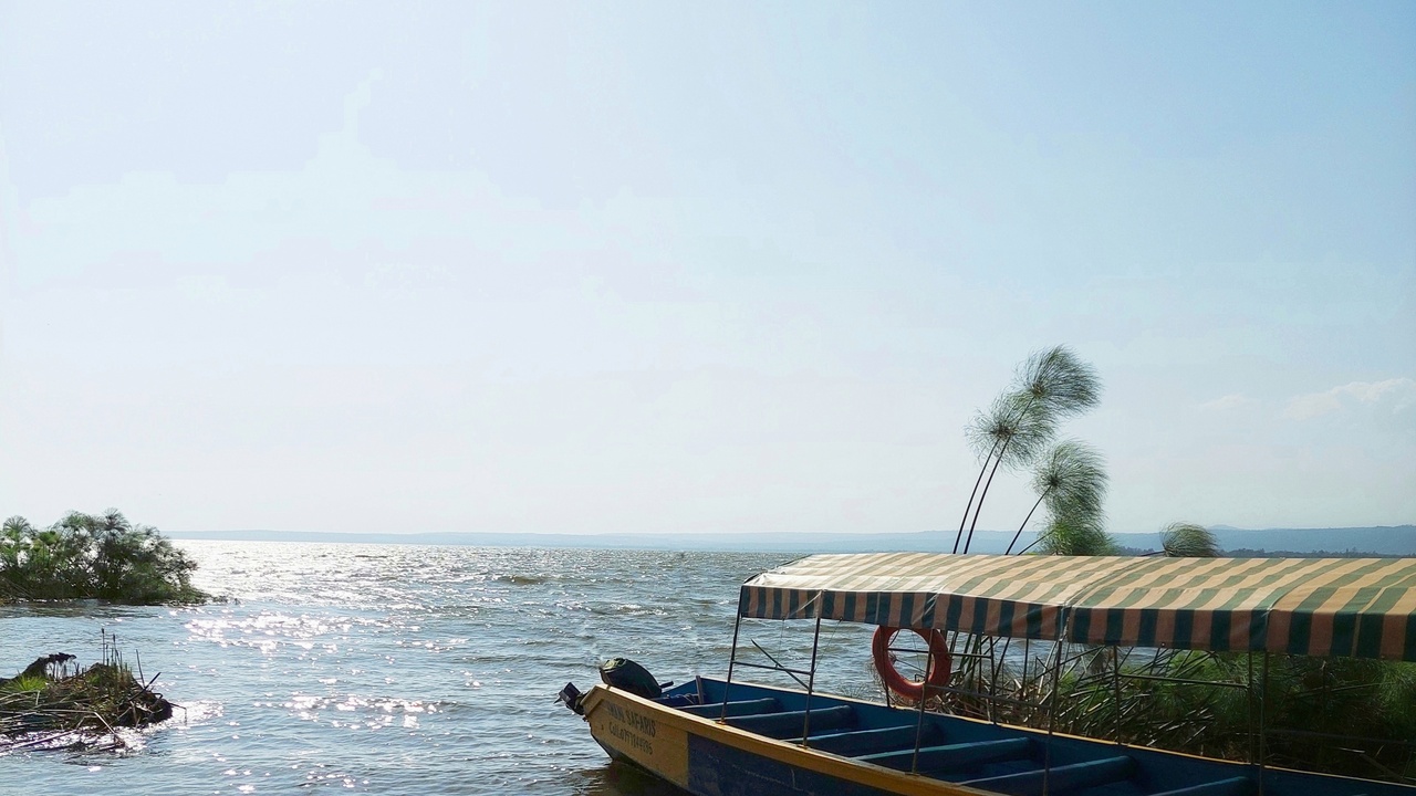 Shoreline of Lake Victoria with fishing boats and distant hills
