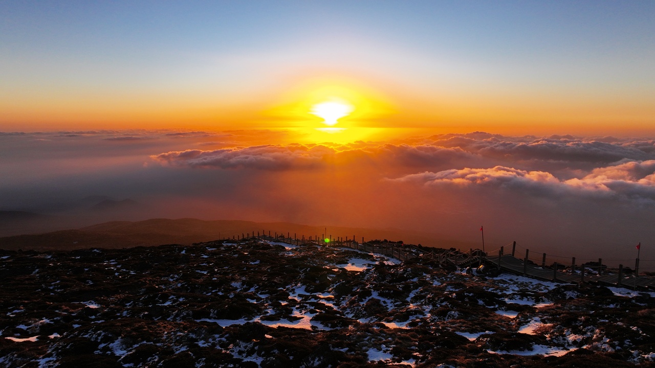 Hiker watching sunrise from Hallasan summit, Jeju