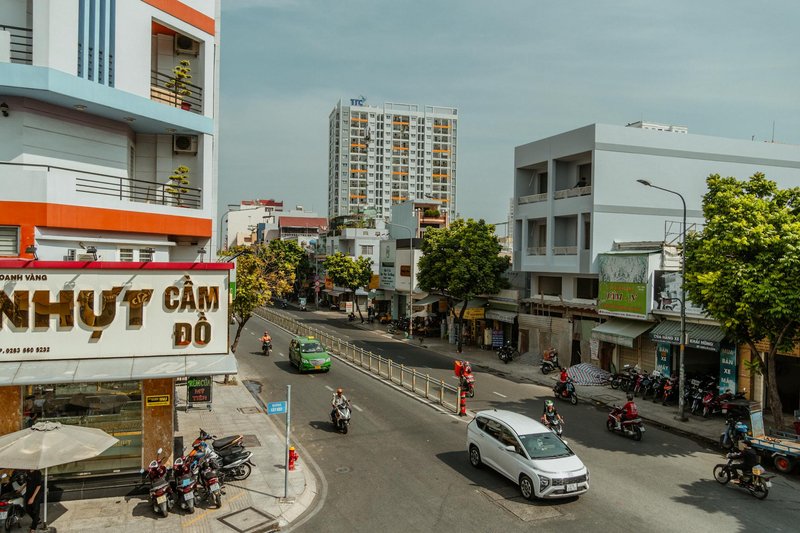 Lively street view in Ho Chi Minh City showcasing vibrant urban life with cars and scooters.