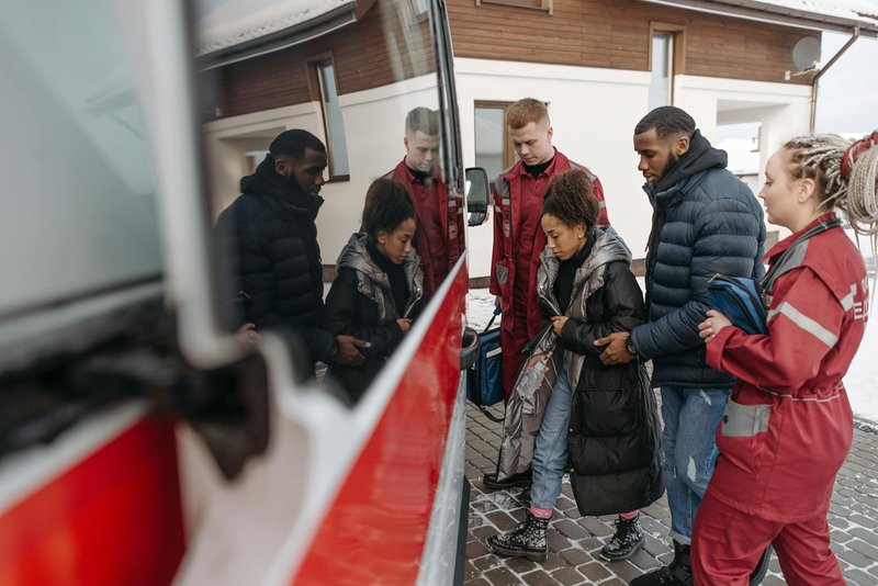 Paramedics assist a woman into an ambulance. A calm, supportive scene showcasing emergency medical care.