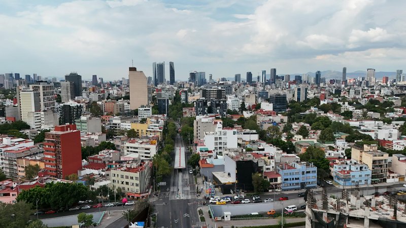 Breathtaking aerial view of Mexico City featuring skyscrapers and dense urban landscape under a cloudy sky.