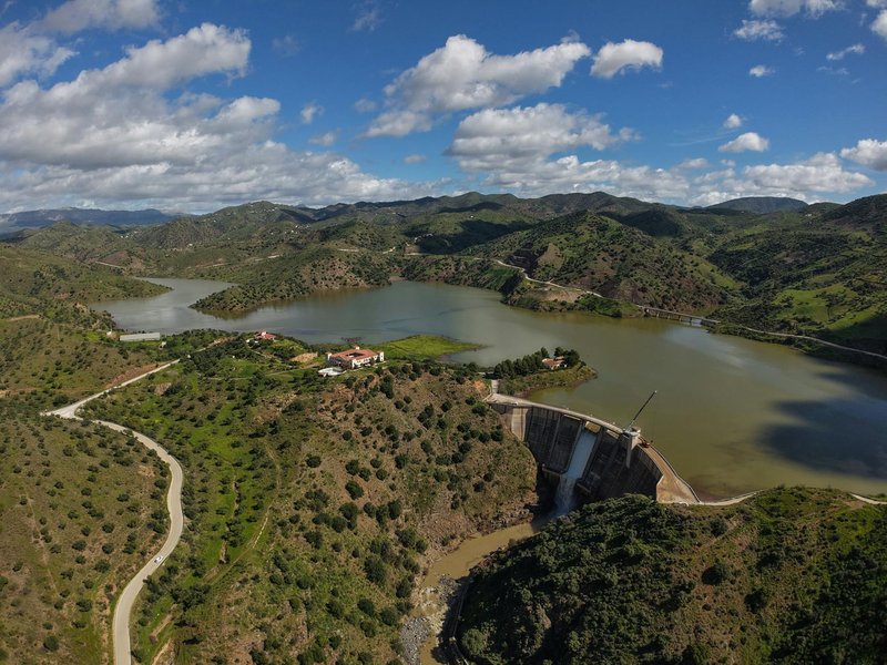 Stunning aerial view of Casasola Reservoir and dam in Almogía, Andalucía, Spain on a sunny day.