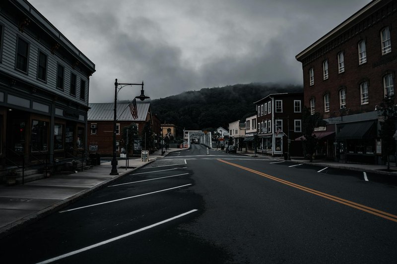 Empty town street with historic buildings and moody clouds. Perfect for travel or urban exploration themes.