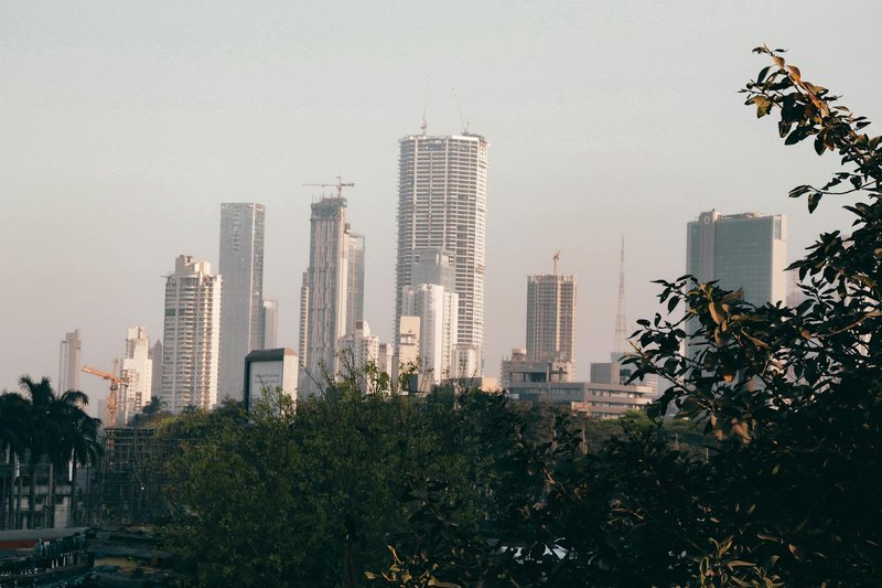 City skyline with skyscrapers and trees during the day, showcasing urban architecture.