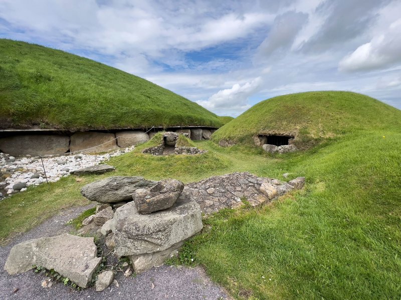 Explore the historic stone burial mounds under a vibrant, cloudy sky.
