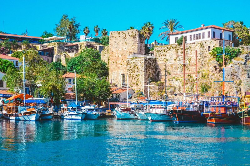 Stunning view of the vibrant marina and historic walls in Antalya, Turkey.