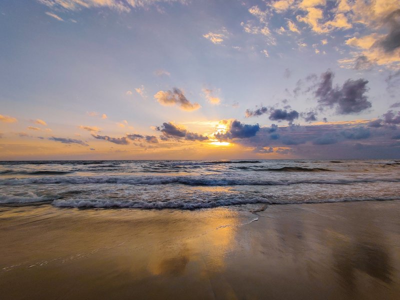 Beautiful sunrise over the ocean with waves gently crashing on Chennai's shoreline.