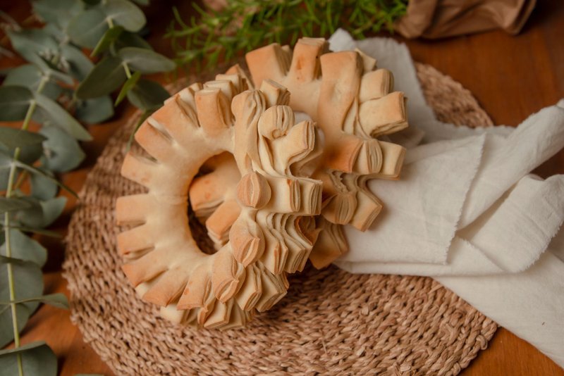 A close-up of traditional Paraguayan chipa bread on a woven mat with white cloth, showcasing artistry and culinary heritage.