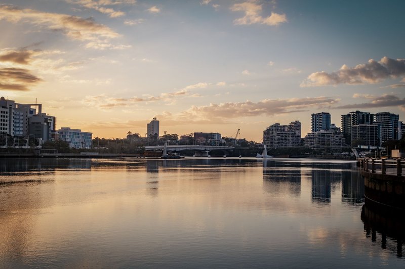 Picturesque sunrise scene over Brisbane River with city skyline reflections. Captivating urban morning view.