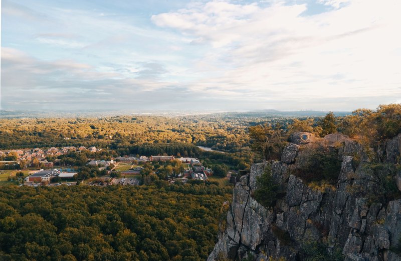 Breathtaking aerial view of Hamden's cliffside overlooking lush forests and distant town.