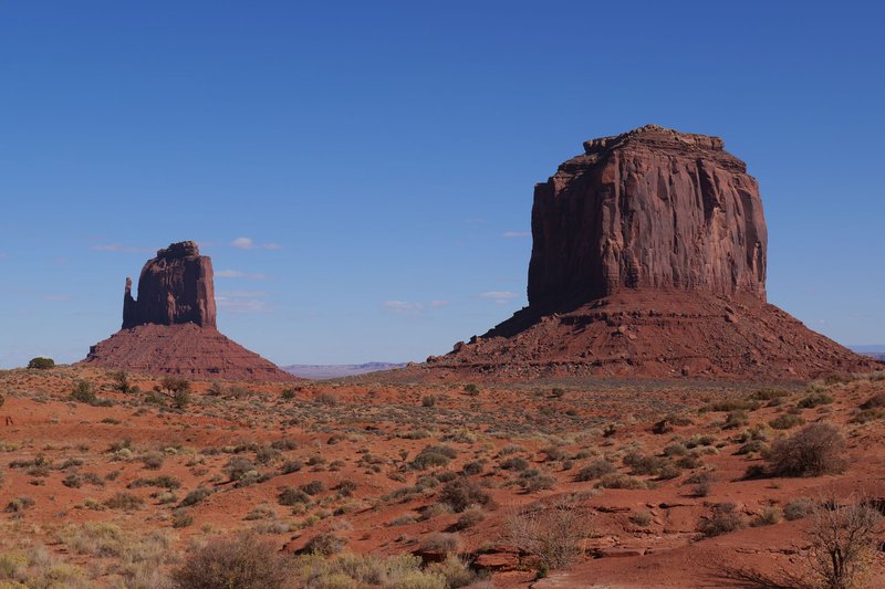Iconic red rock formations of Monument Valley under a clear blue sky.