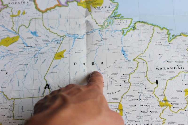 A close-up of a hand pointing at the state of Pará on a map of Brazil.