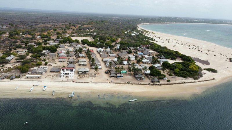 A stunning aerial shot of a coastal village in Lamu County, Kenya, featuring sandy beaches and clear ocean waters.