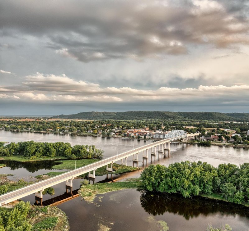 Aerial view of the Wabasha Bridge spanning the Mississippi River amidst lush greenery and cityscape.