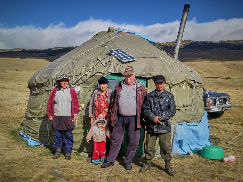 A Mongolian family standing outside a traditional ger in the highlands.