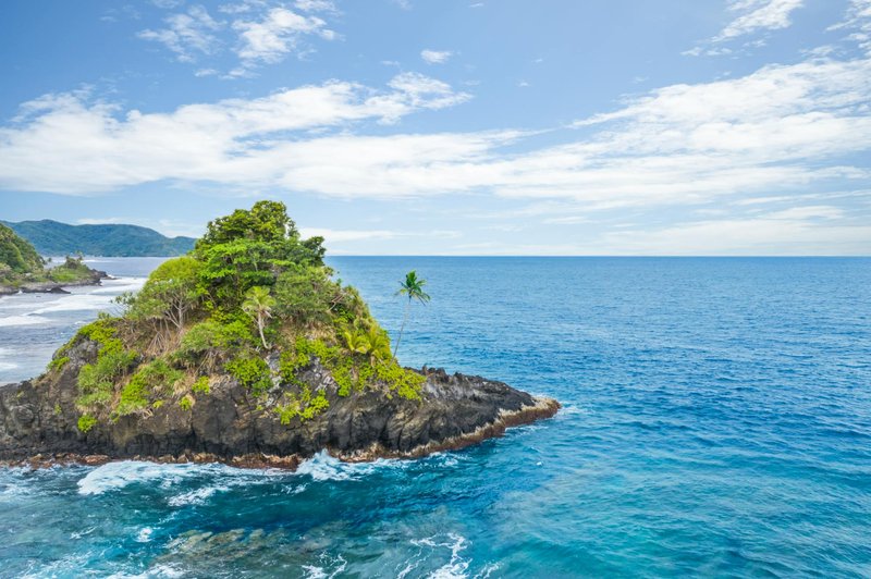 Explore the stunning Alega Beach with vibrant turquoise waters and lush greenery in American Samoa.