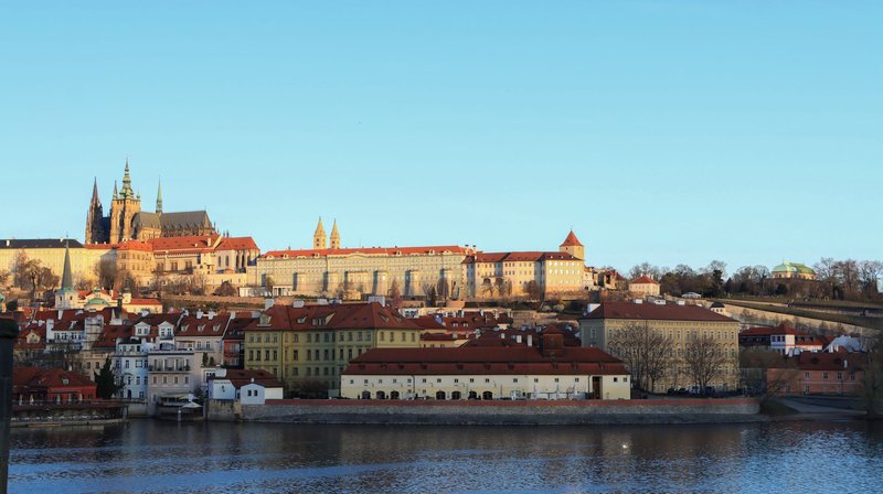 Stunning view of Prague Castle and the Vltava River in summer sunlight.