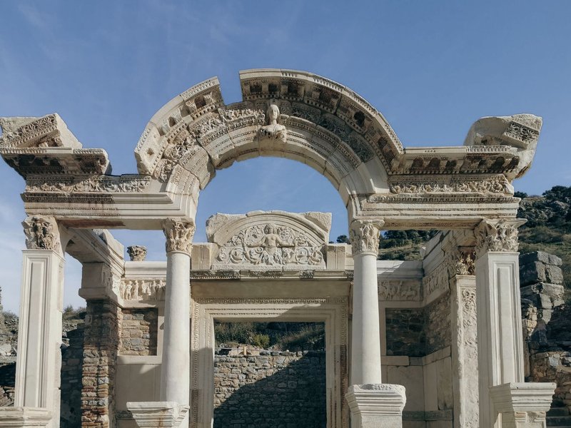 A stunning view of ancient Roman ruins featuring a detailed arch under a clear sky.