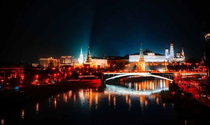 Stunning night view of Moscow's illuminated skyline with reflections on the river.