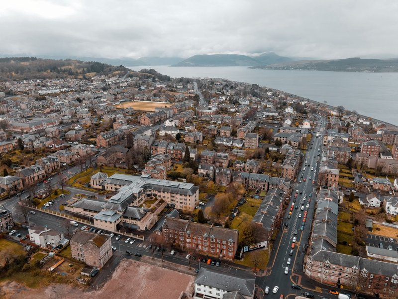 Stunning aerial view of a coastal Scottish town featuring roads, houses, and the sea.
