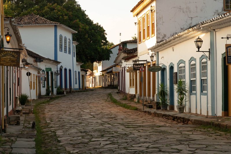A serene cobblestone street lined with colorful colonial buildings in a historic Brazilian town, perfect for travel and architecture themes.