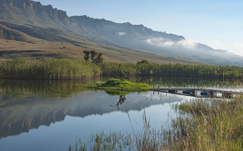 Serene landscape of a peaceful lake reflecting mountains in Highmoor, South Africa.
