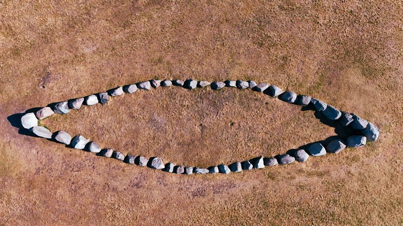 Aerial shot of an ancient stone circle on grassy terrain in Jönköping, Sweden.