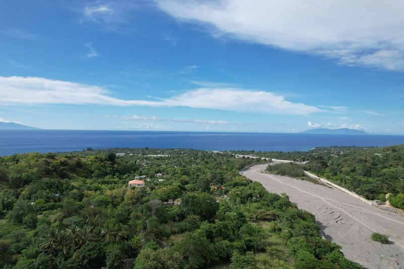 A scenic aerial view capturing the lush countryside and serene ocean of Liquica, Timor-Leste.
