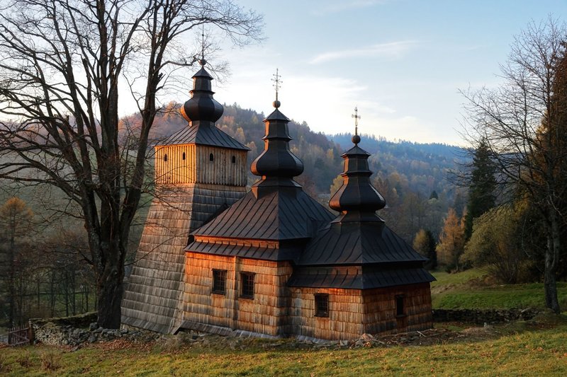 Captivating view of a historic wooden church in Dubne, Poland during a serene sunset.