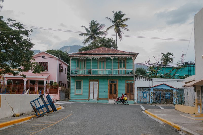 Charming Caribbean style street scene with colorful houses and palm trees.