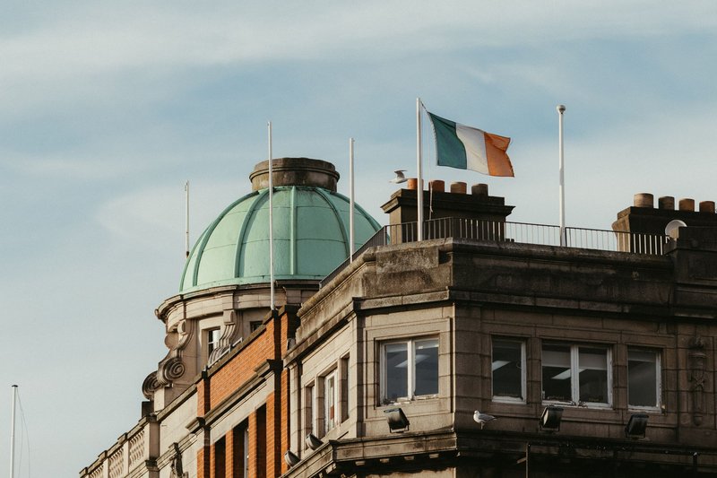 Historic Dublin architecture with the Irish flag waving prominently on a sunny day.