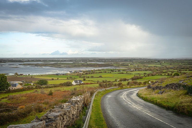 Explore the breathtaking Burren landscape featuring a winding road leading to the sea in Ireland.