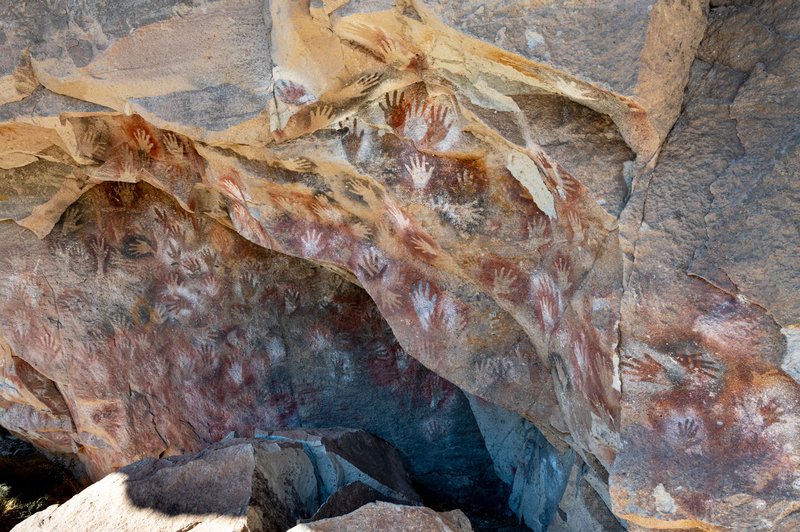 Rock art depicting ancient handprints on cave walls in Santa Cruz, Argentina.