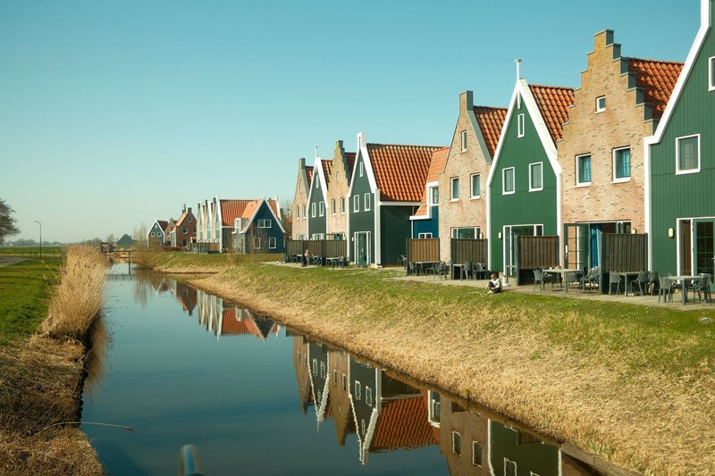 Traditional Dutch houses reflecting in a canal in Volendam, North Holland, Netherlands.