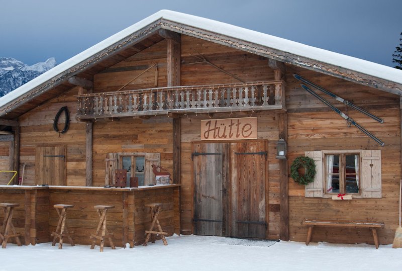 A cozy rustic wooden chalet in a snowy winter mountain setting, perfect for a getaway.