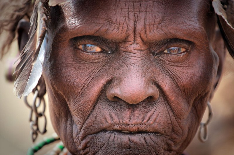 Detailed face of an elderly woman showcasing deep wrinkles and traditional adornments.