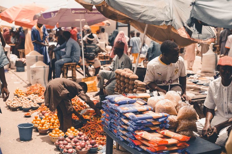 Lively market scene showcasing fresh produce and vendors under colorful umbrellas, capturing the essence of local trade.
