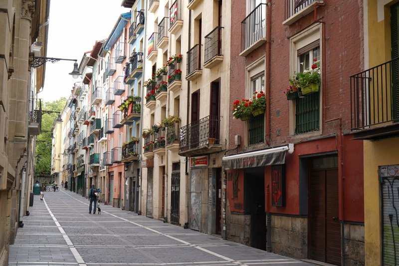Explore a vibrant street in Pamplona, Spain, featuring a row of colorful residential buildings.