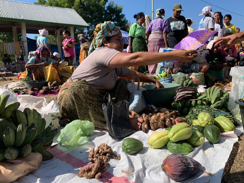 A lively market scene capturing vendors selling fresh produce in Flores, Indonesia, showcasing cultural richness.