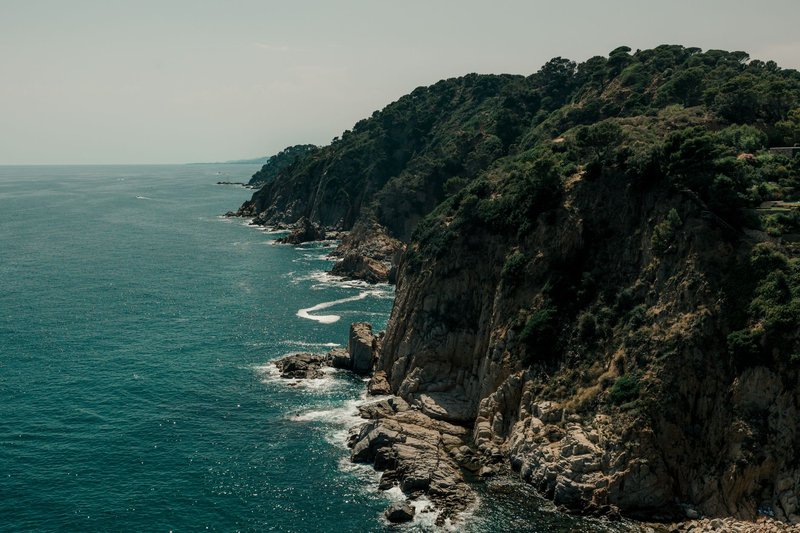 Stunning view of the rugged cliffs and azure sea in Tossa de Mar, Catalonia, Spain.