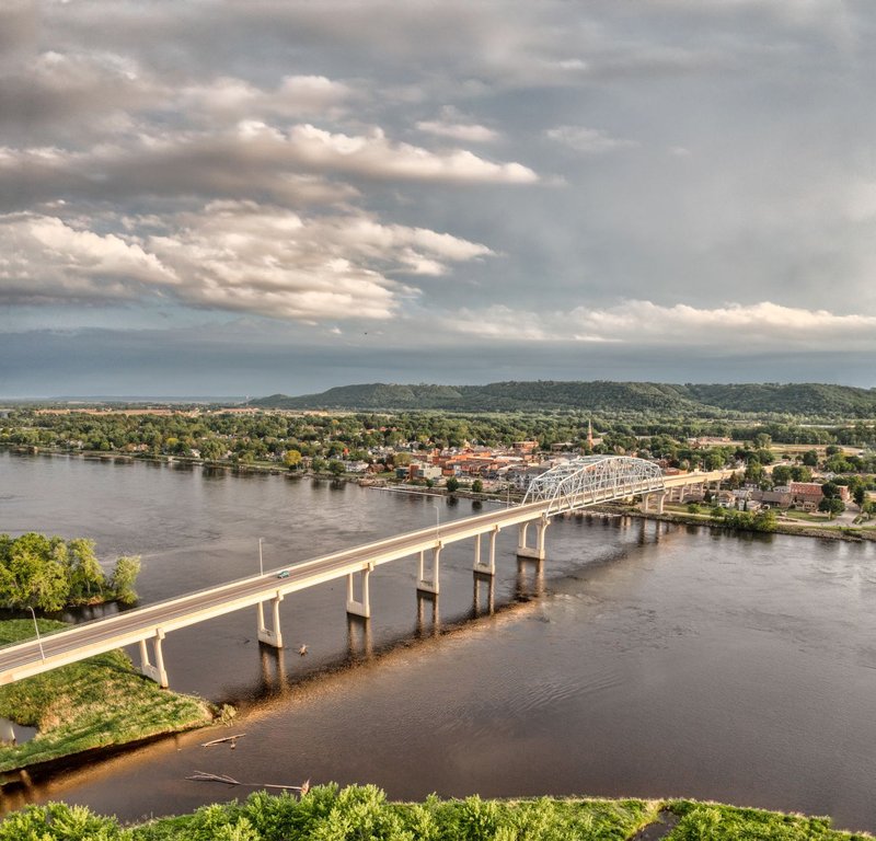 Scenic aerial view of a bridge spanning the Mississippi River in Wabasha, Minnesota under a cloudy sky.