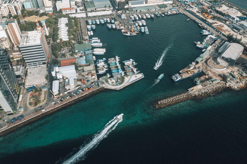 Aerial view of a bustling marina with motorboats and city buildings, capturing urban life.