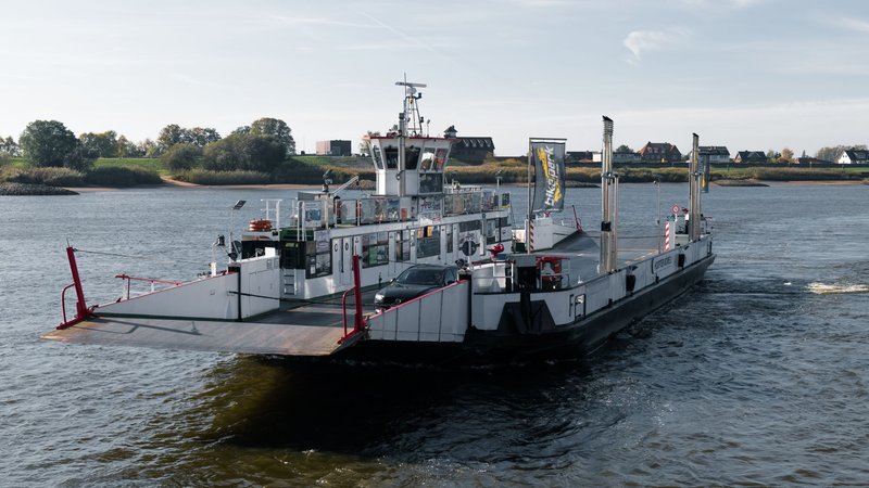 Ferry transporting cars across the Elbe River in Hamburg, capturing serene waterside views.
