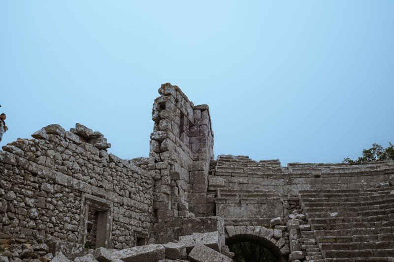 Stone ruins with a clear blue sky above, depicting historical architecture.