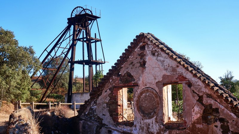 Explore the rustic beauty of an abandoned mine headframe and decaying building in Portugal's countryside.