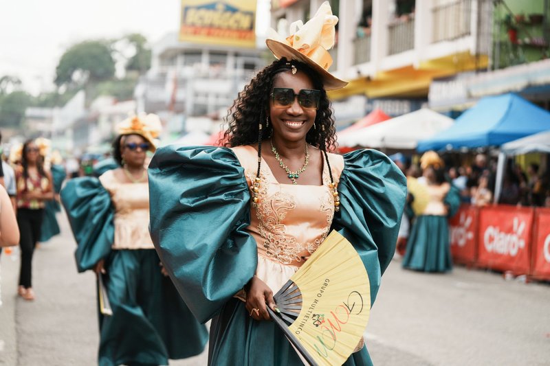 Vibrant Afro-Caribbean parade in Limón, Costa Rica, featuring costumed dancers with fans.